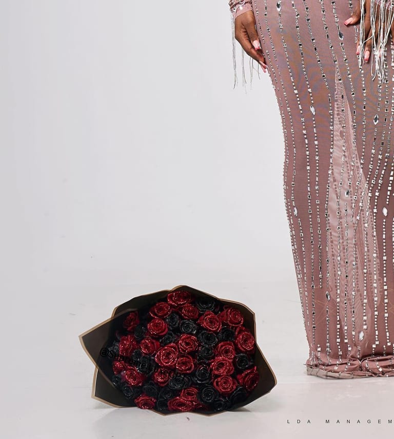 Supreme Luxe bespoke — couture detail beside a red and black rose bouquet